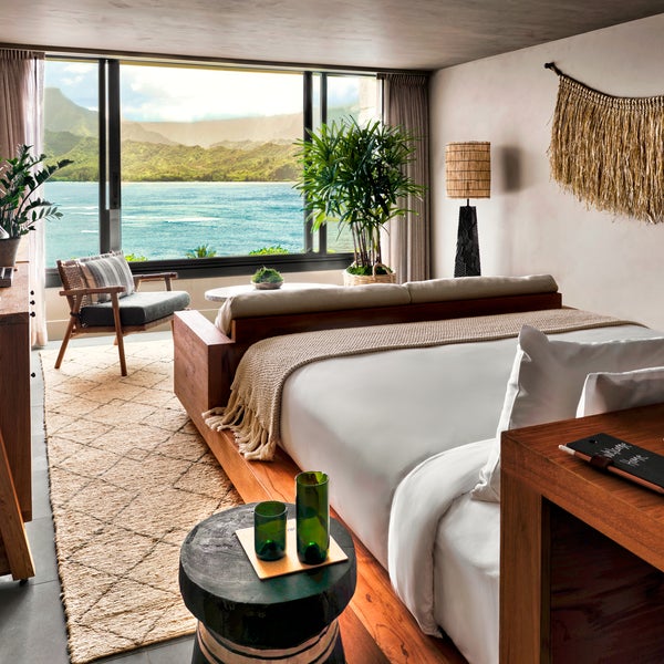 A bedroom with a view of the ocean just outside