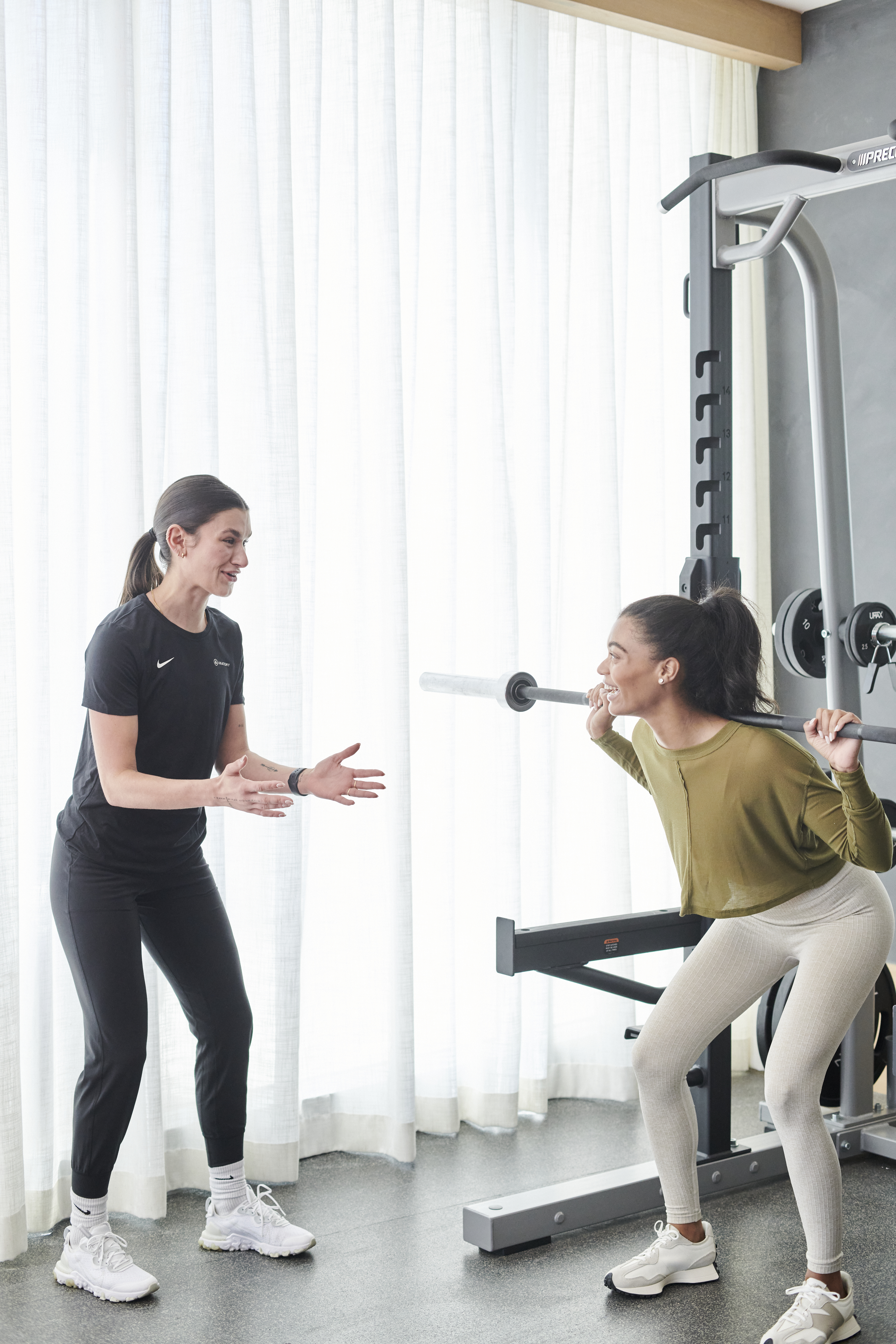 Personal trainer working with person doing a squat