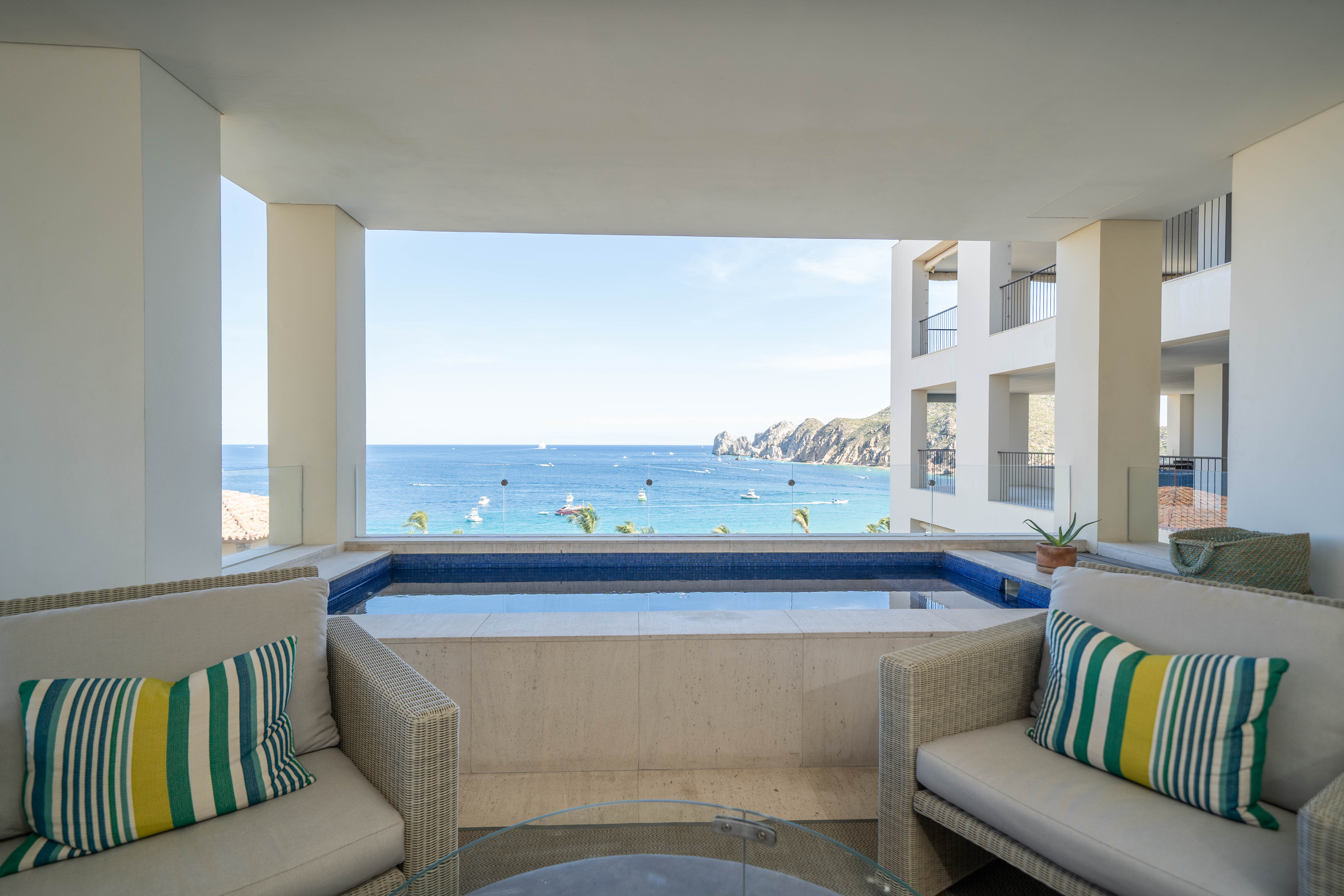 A view out to the ocean from a room with a pool