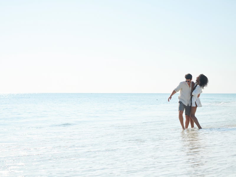 Two people walking together in the water