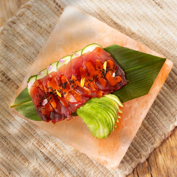 raw tuna slices plated on a banana leaf