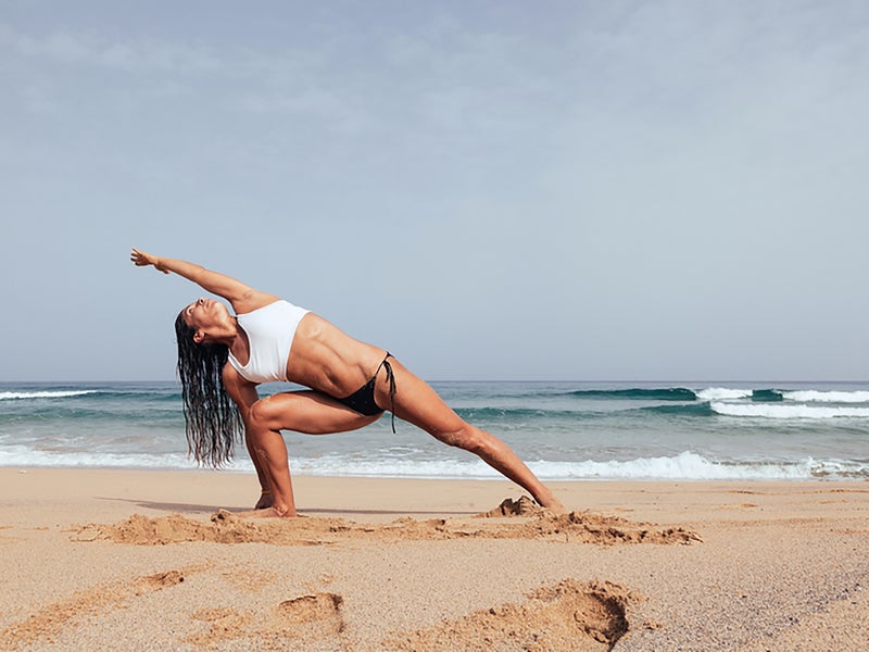 Person doing yoga on the beach