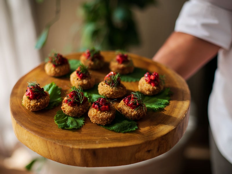 A wooden platter full of delicious appetizers