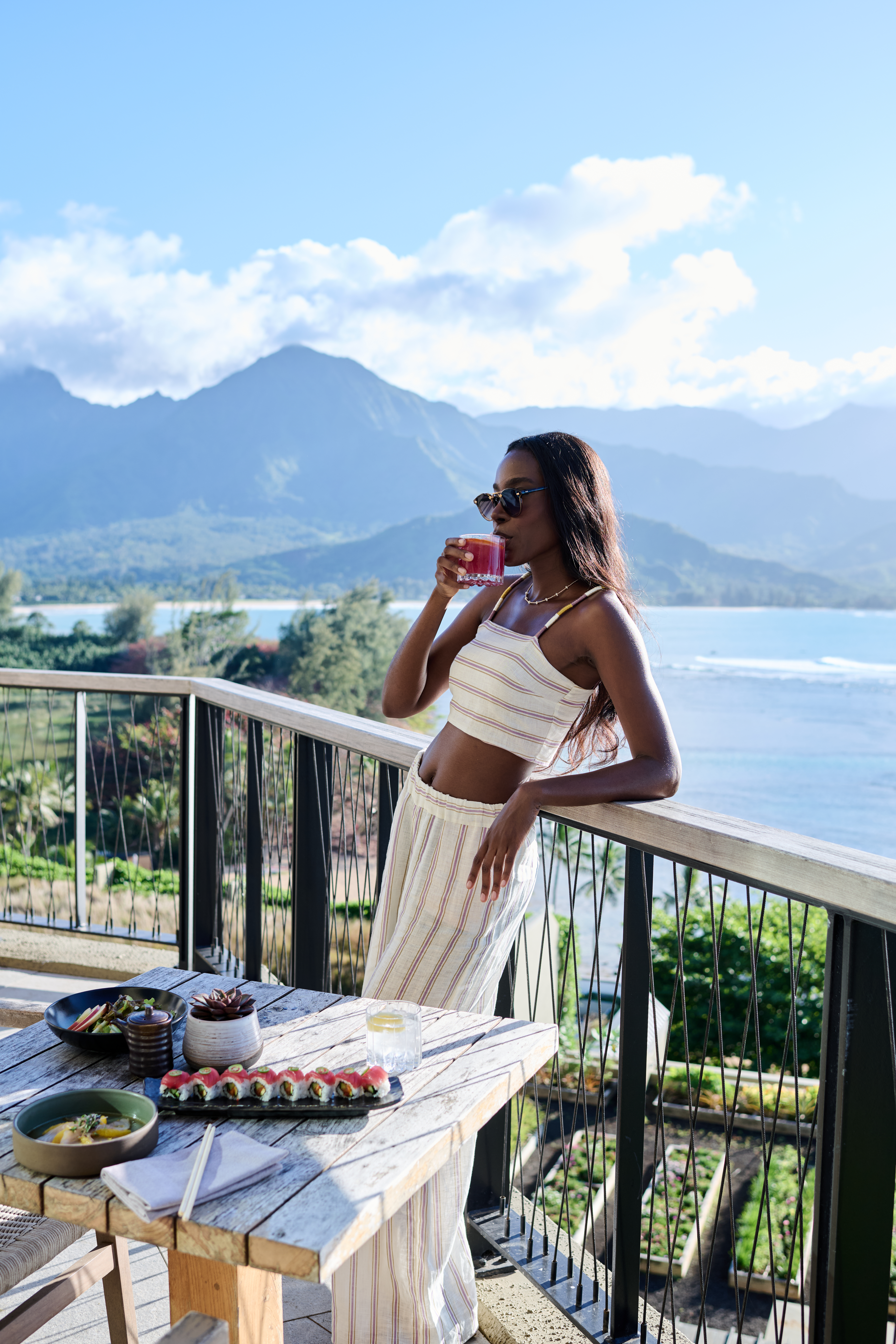 Woman haven a cocktail with landscape behind her