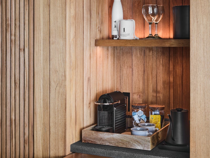 In room bar with nespresso machine and drawer full of snacks