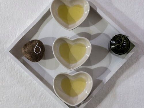 A plate with 3 heart shaped bowls containing a yellow liquid