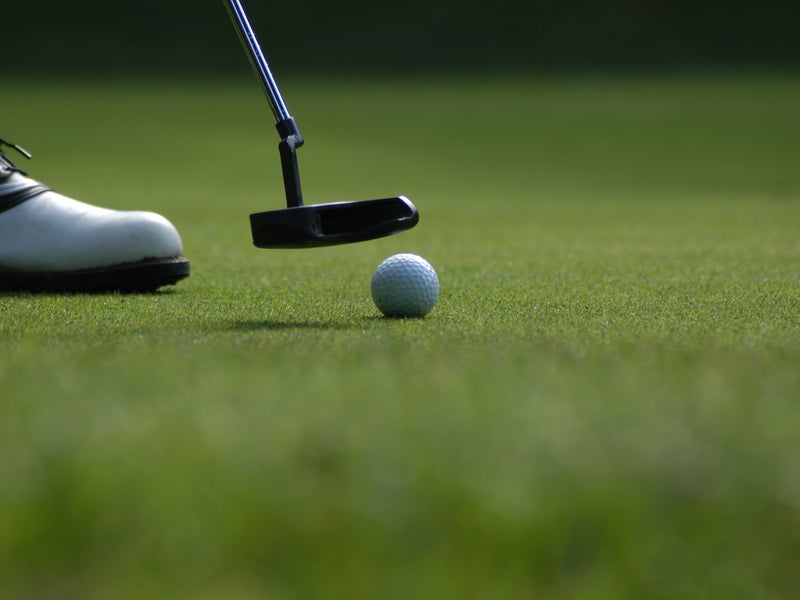 Person putting in golf