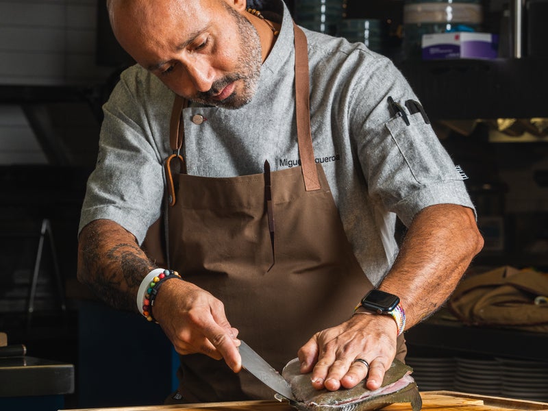 Chef Miguel Figueroa carving a fish