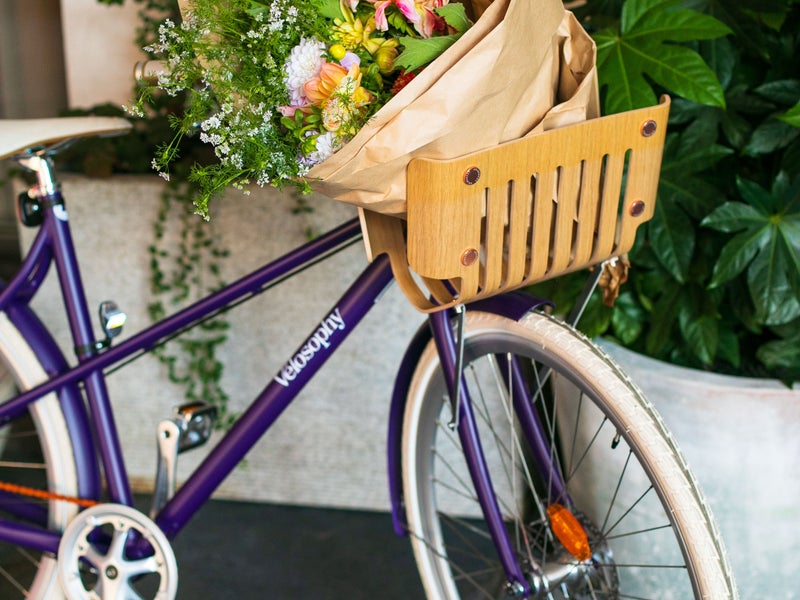 A bike with a bag of flowers in the basket