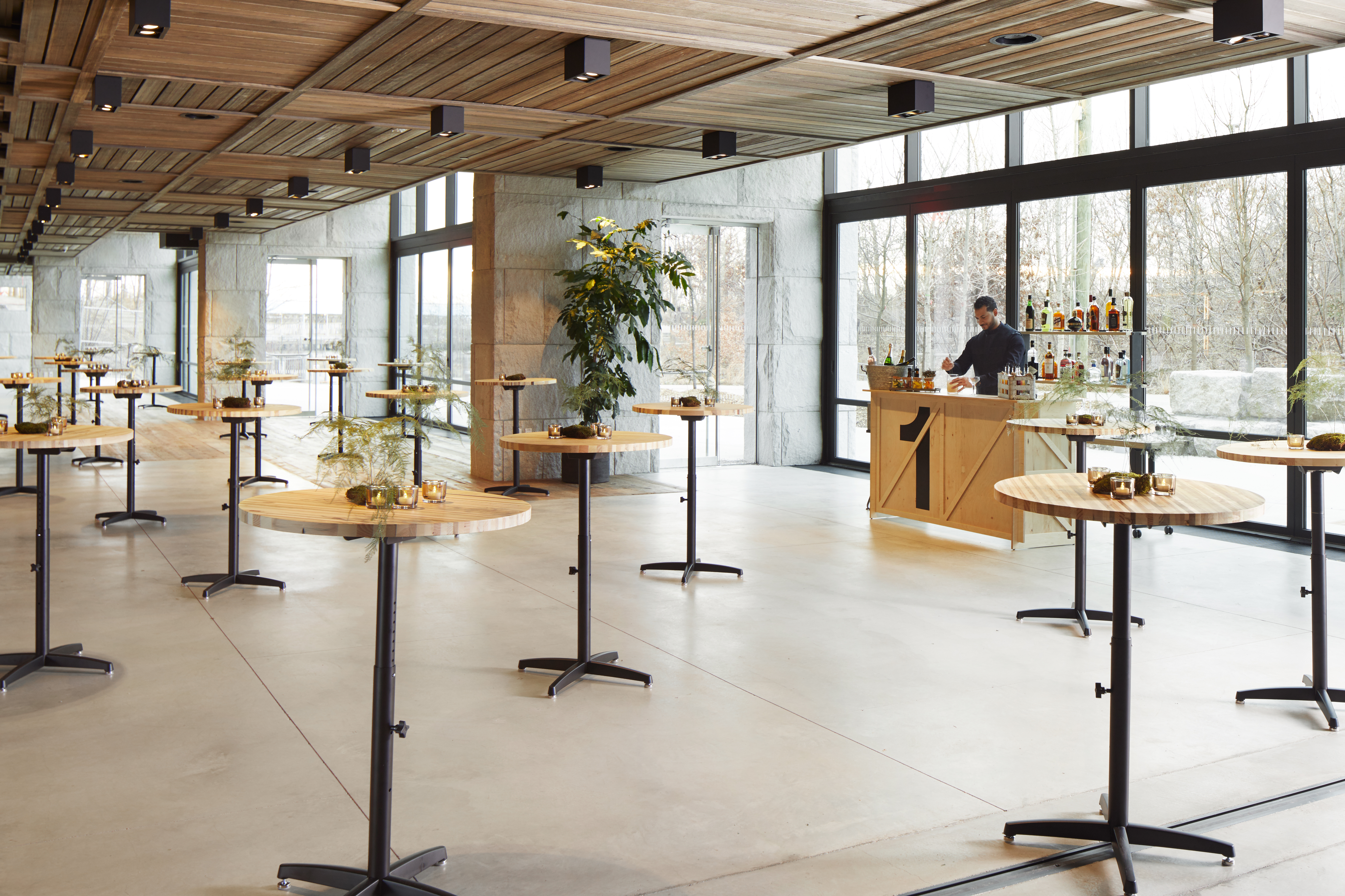 Room filled with tall windows and tall round small tables