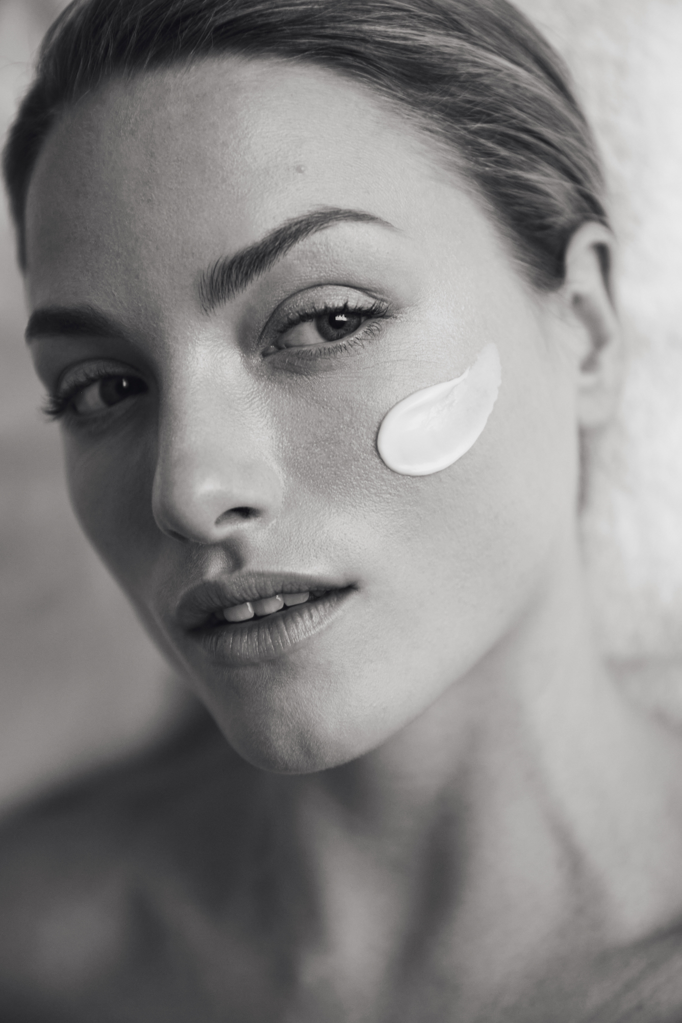 A person with a smear of lotion on their cheek