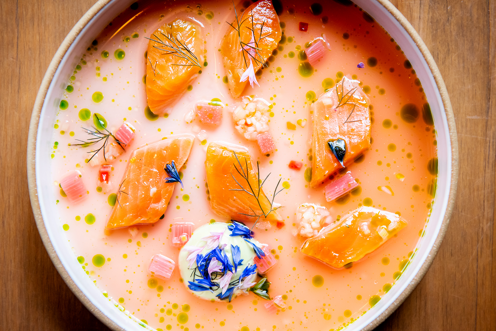 A colourful dish of trout crudo, in a creamy broth