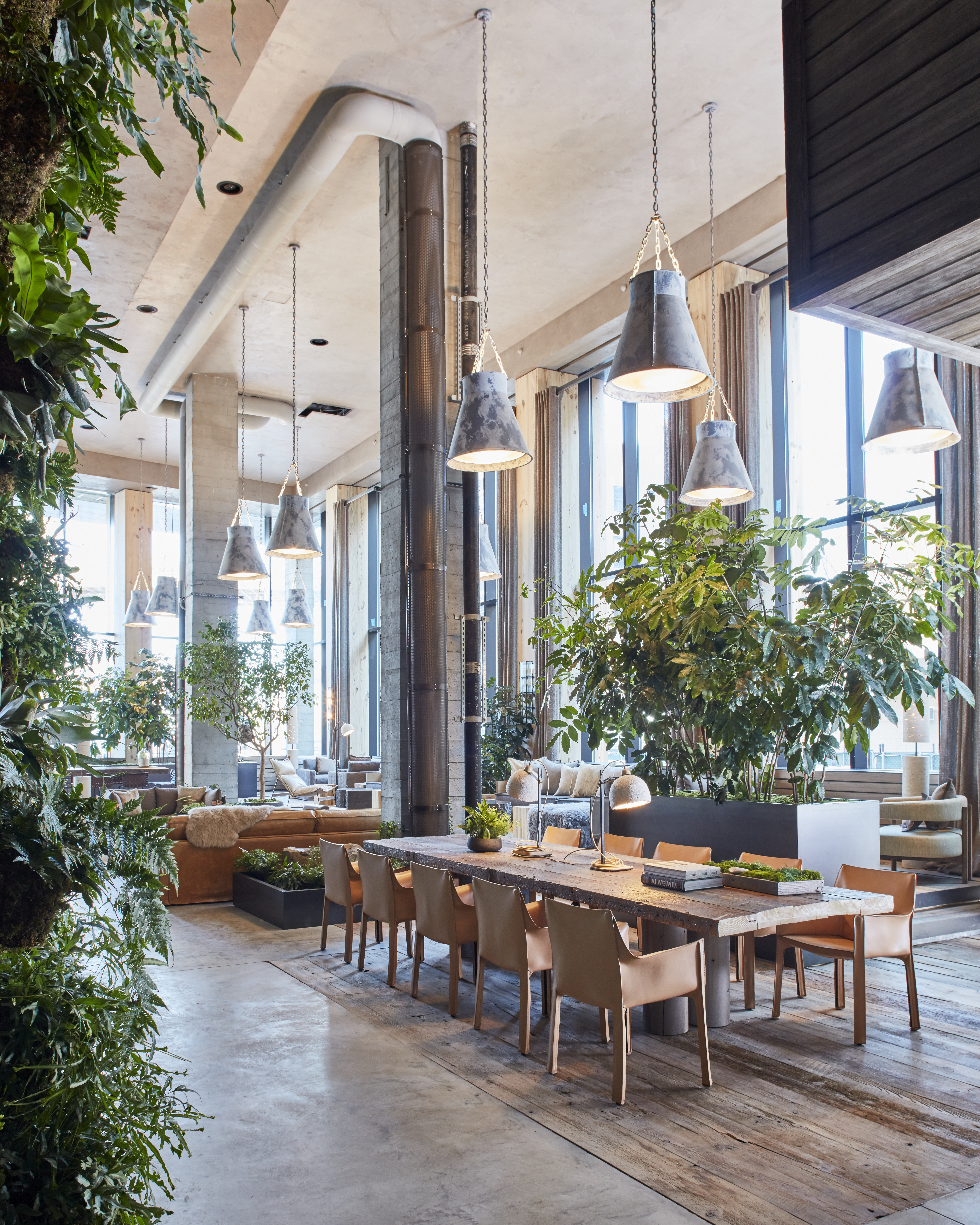 Hotel lobby with large wooden table and greenery 