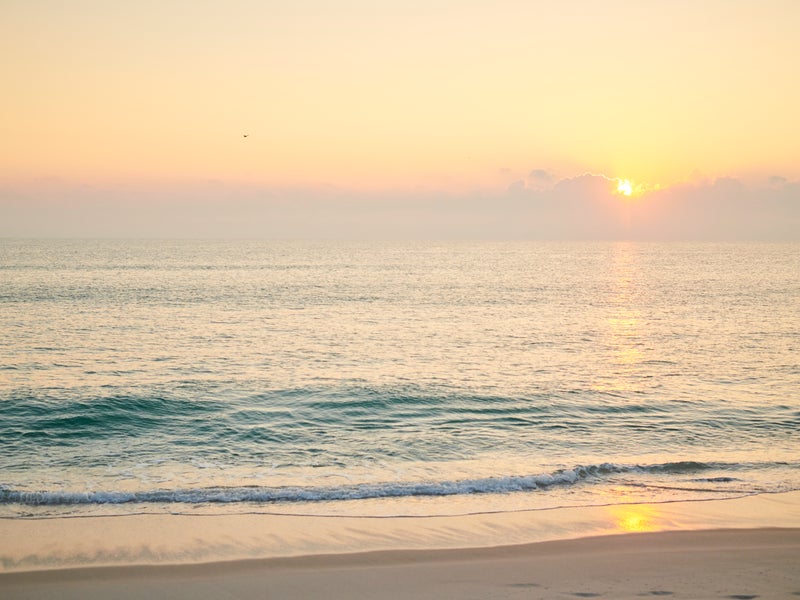 Waves crashing on a beach at sunset