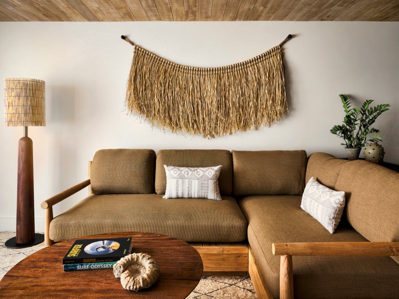A sectional couch with a macrame wall hanging