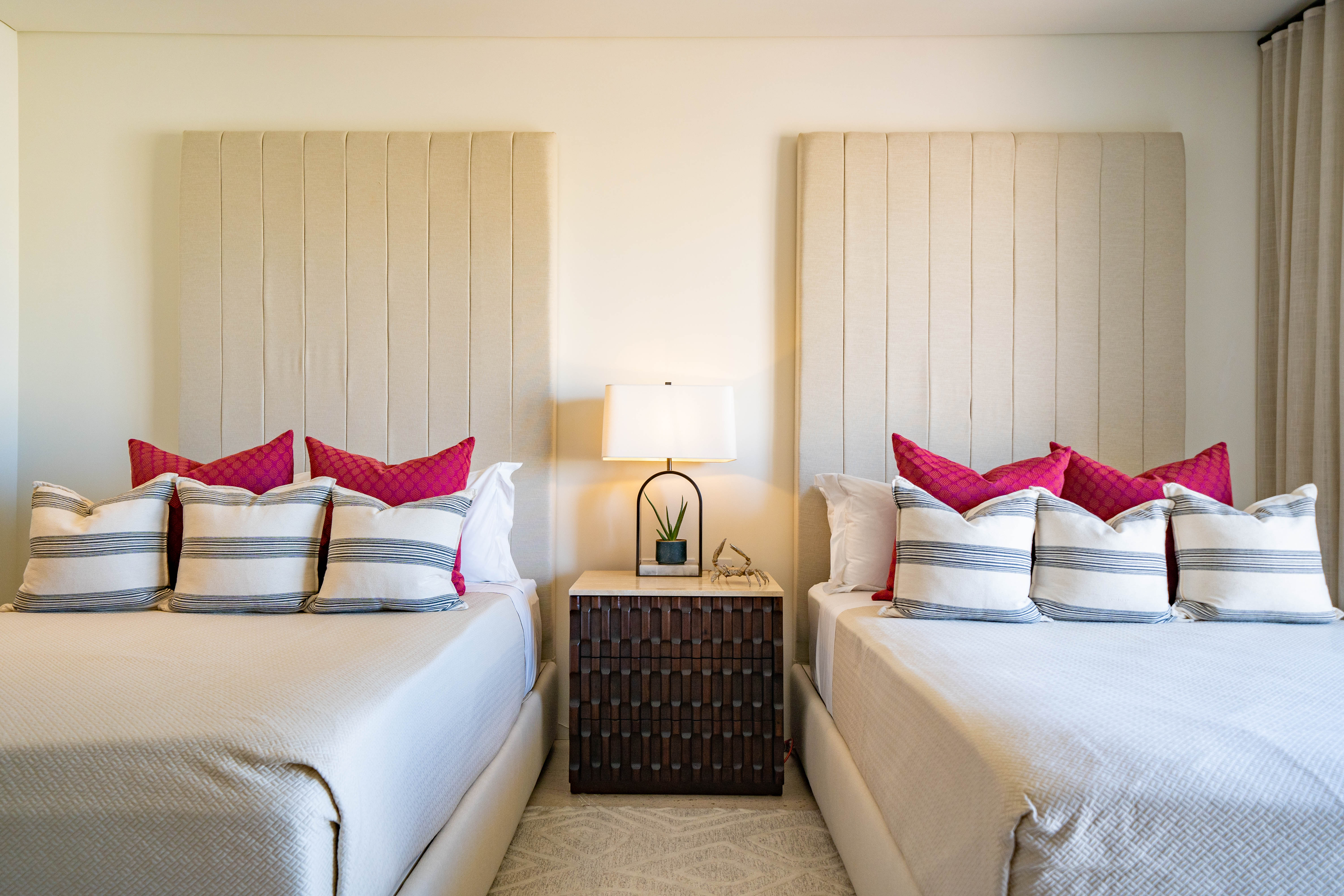 Two beds side by side with a night stand in the middle