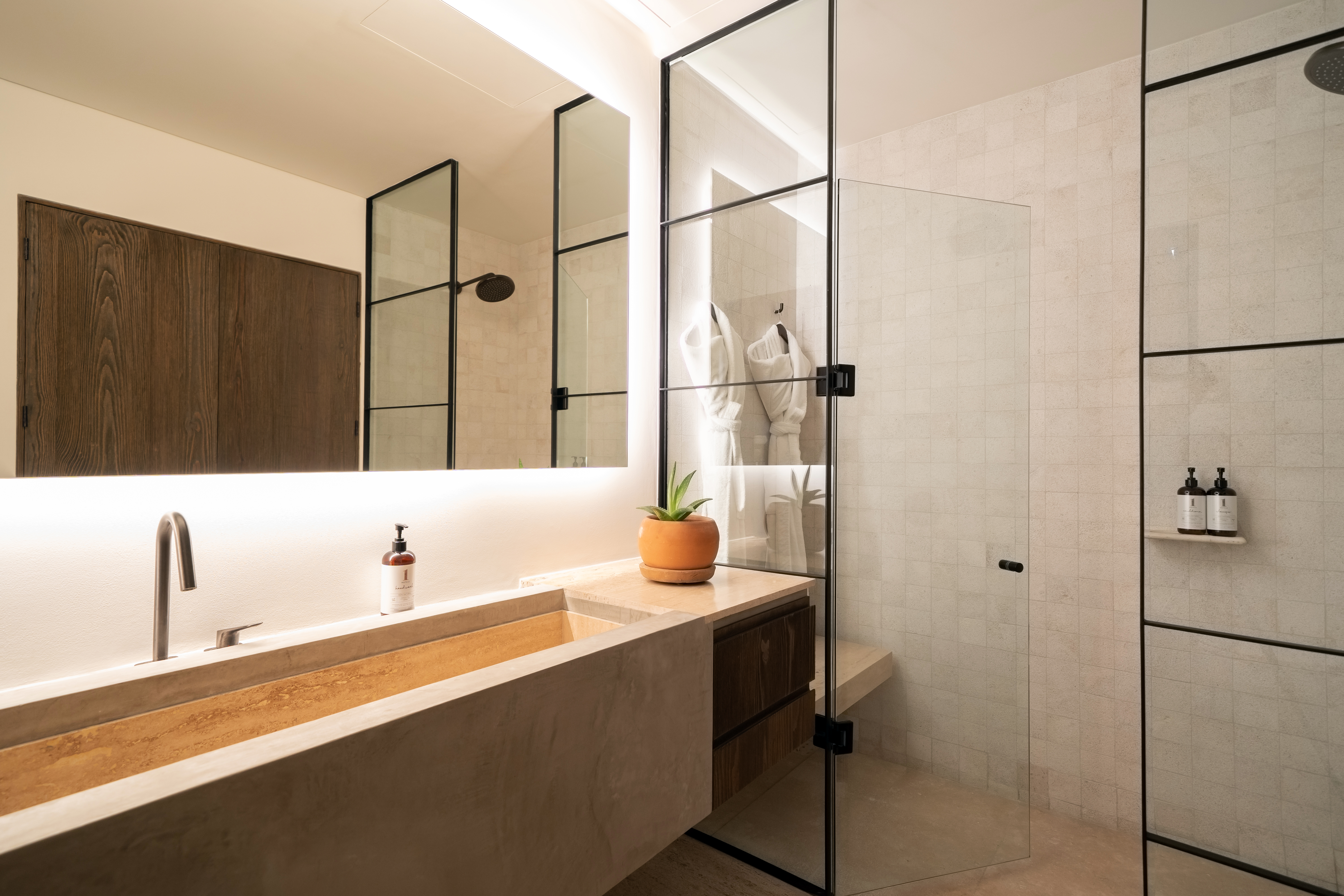 A wide bathroom sink next to a glass shower