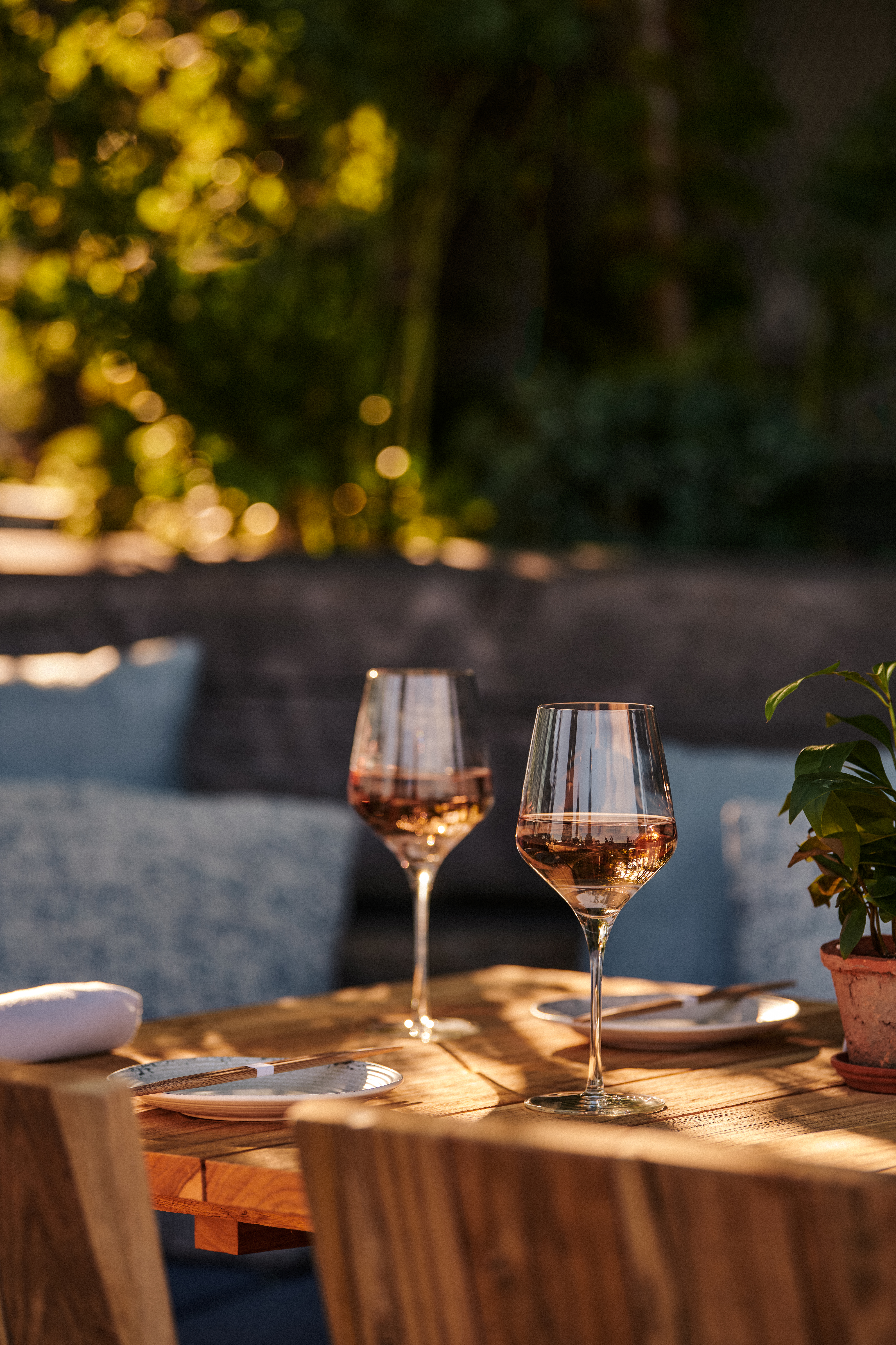 Two rose wine glasses on a wooden table at Harriet's Rooftop