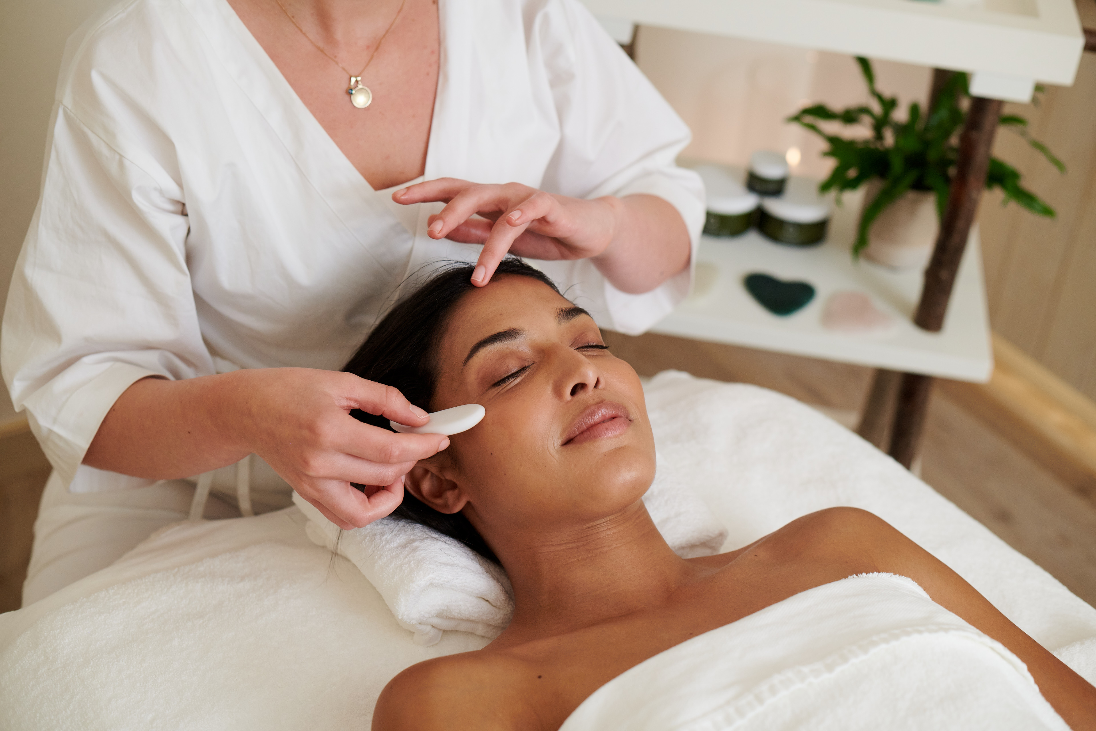 A woman smiles while receiving a massage at a spa.