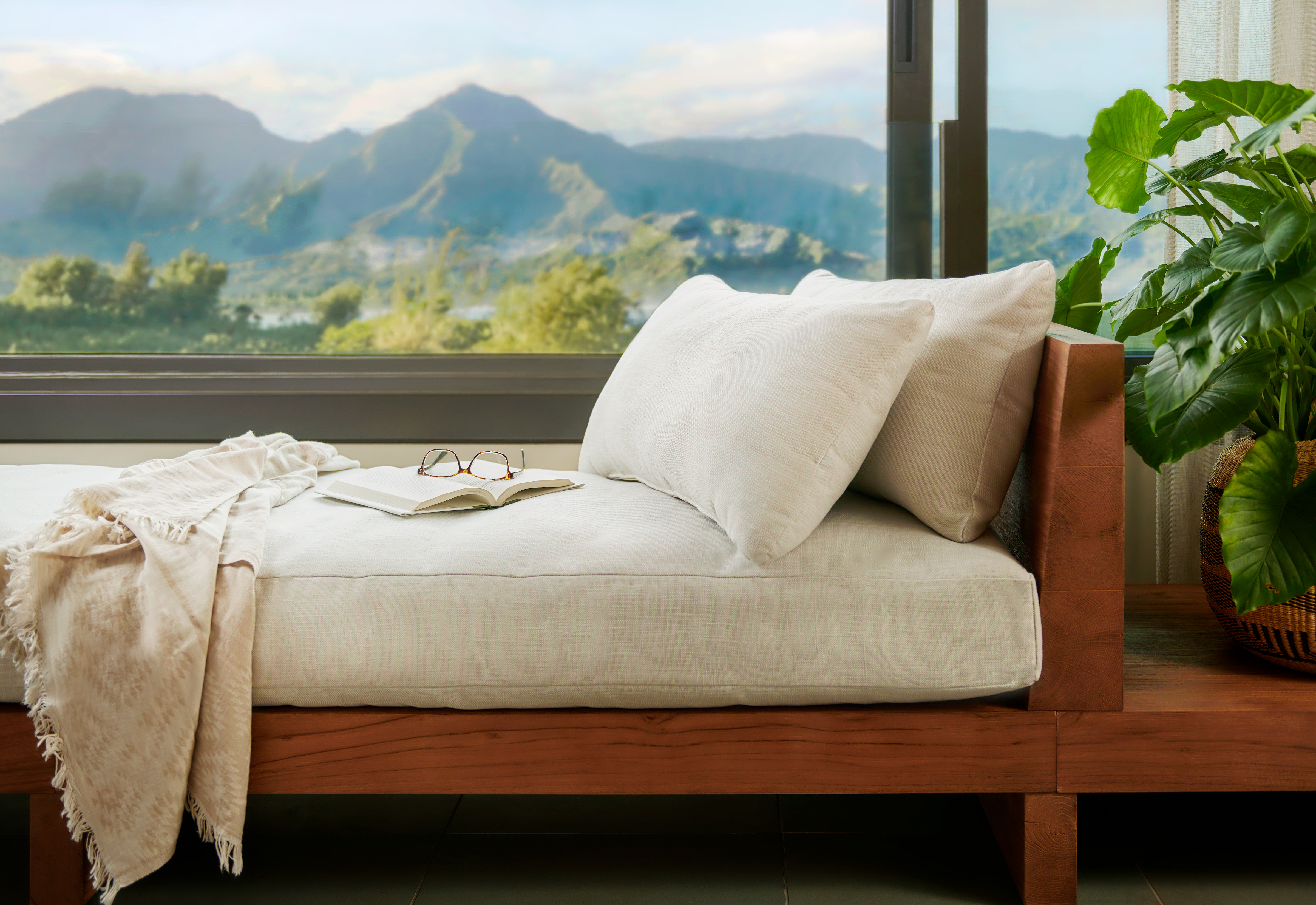 Pair of glasses resting on a book on a lounge chair