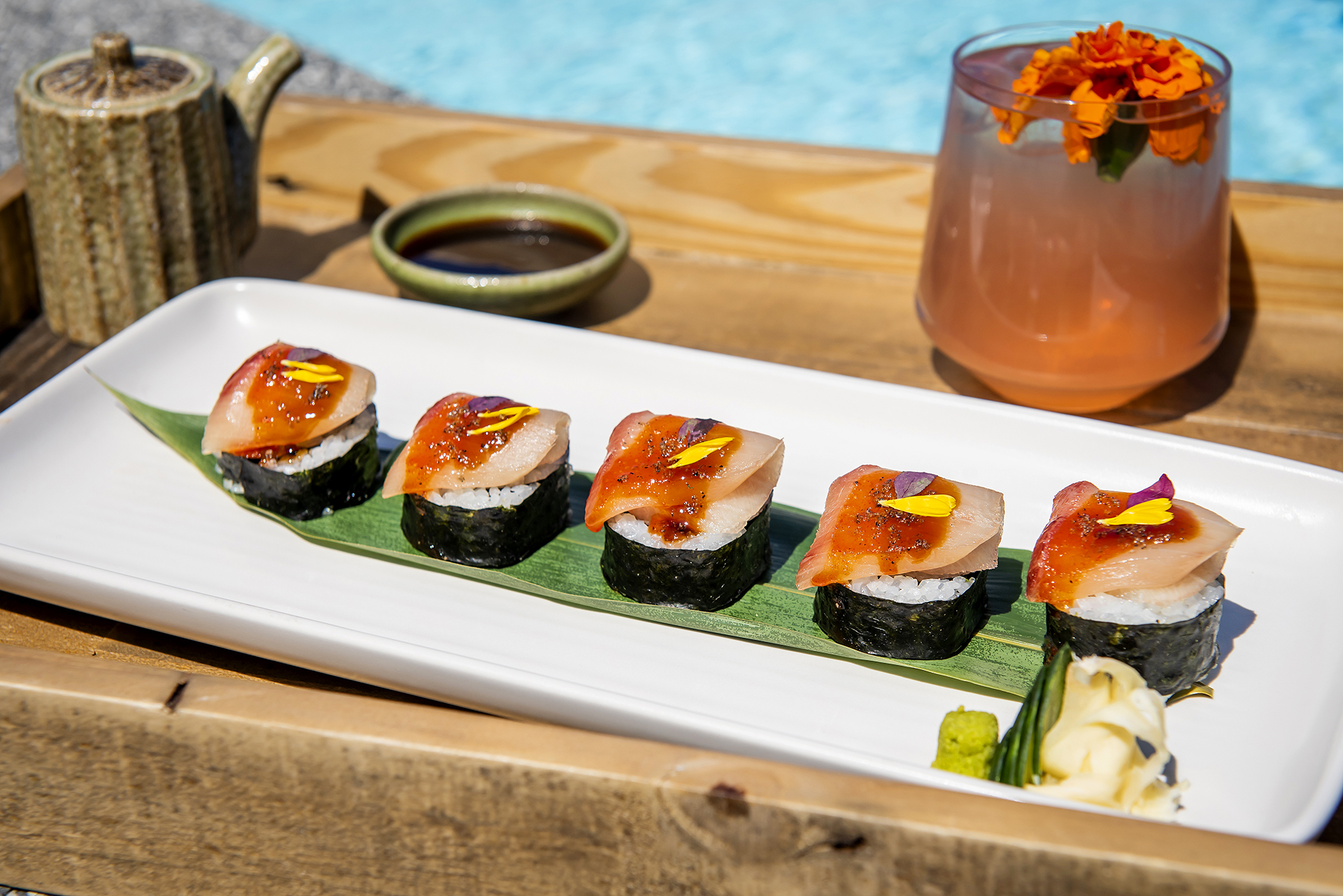 Sushi plate with cocktail by the pool