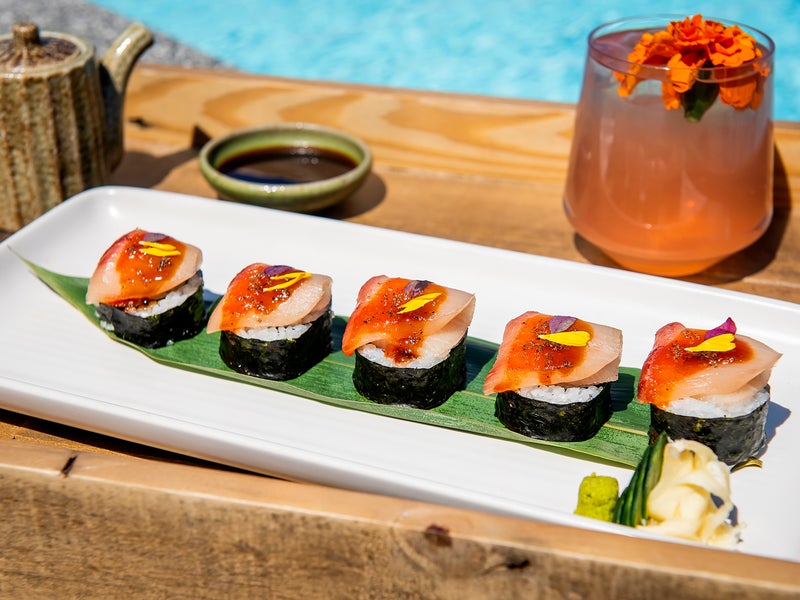 Sushi plate with cocktail by the pool