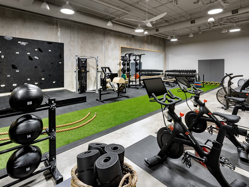 Workout area with machines and a strip of turf