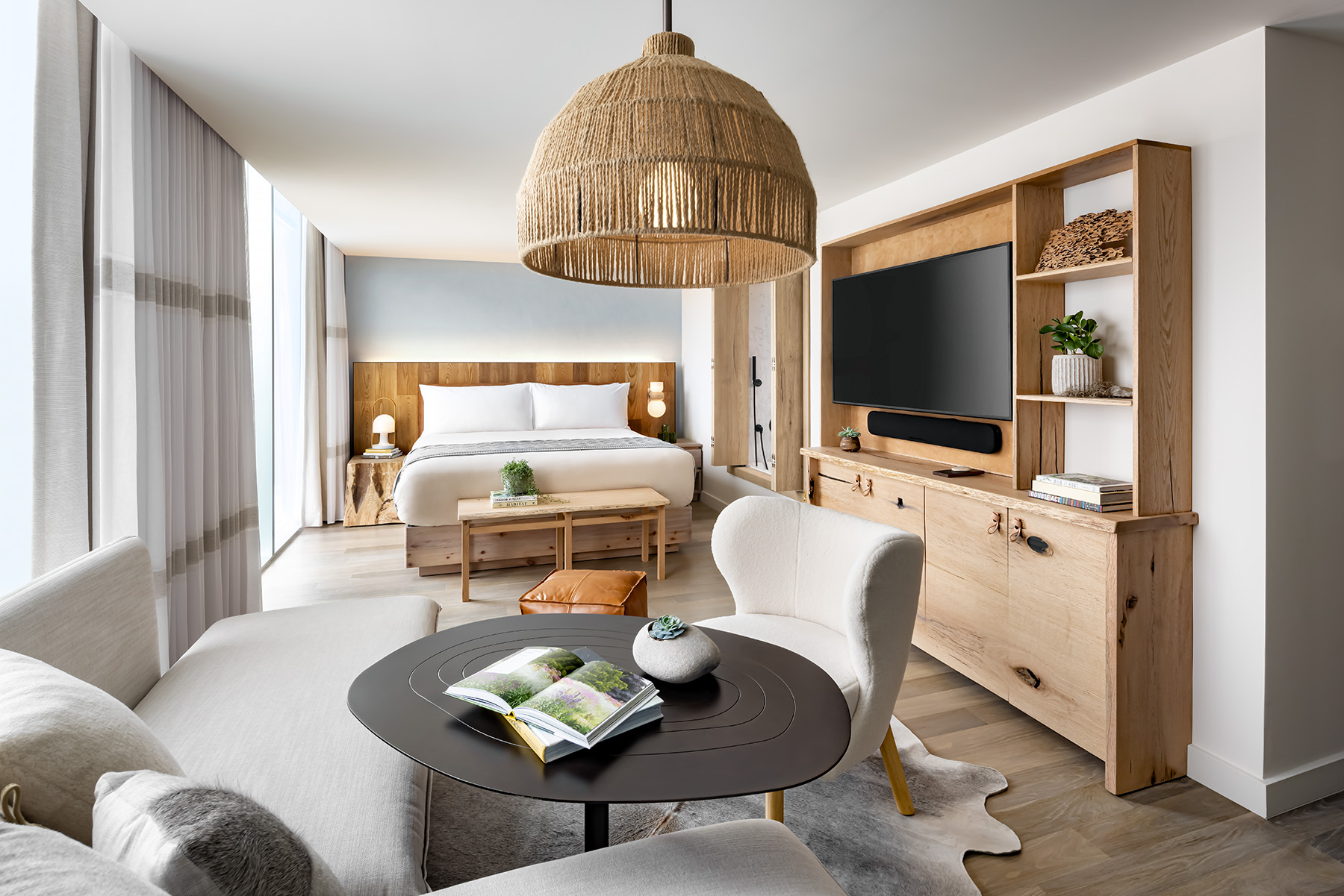 A guestroom with large sectional, king size bed, and television