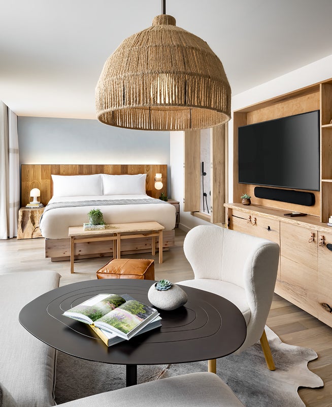 A guestroom with large sectional, king size bed, and television