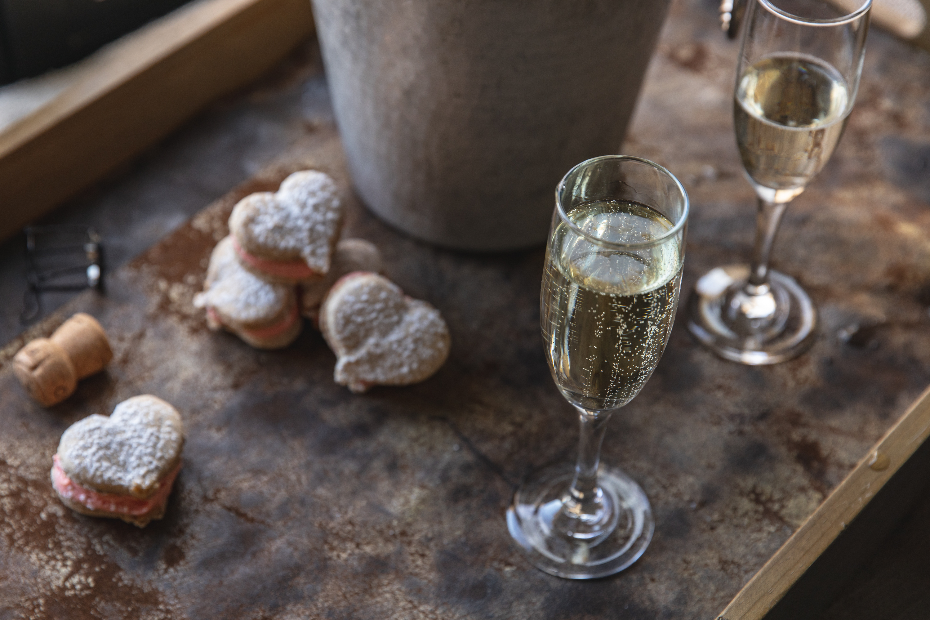 Powdered heart shaped pastries adjacent to a bottle of champagne
