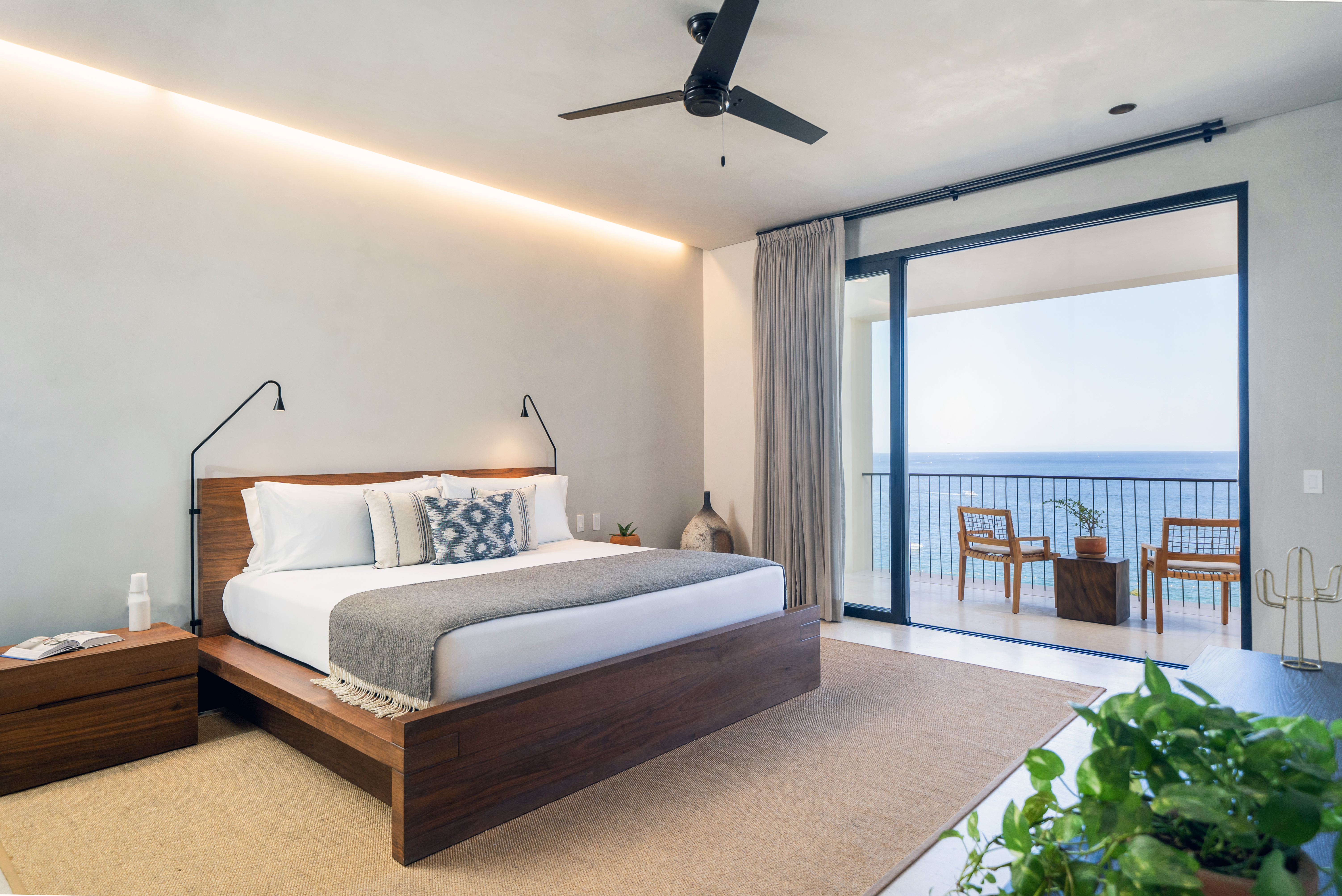 A large king size bed with views of the ocean from a private patio
