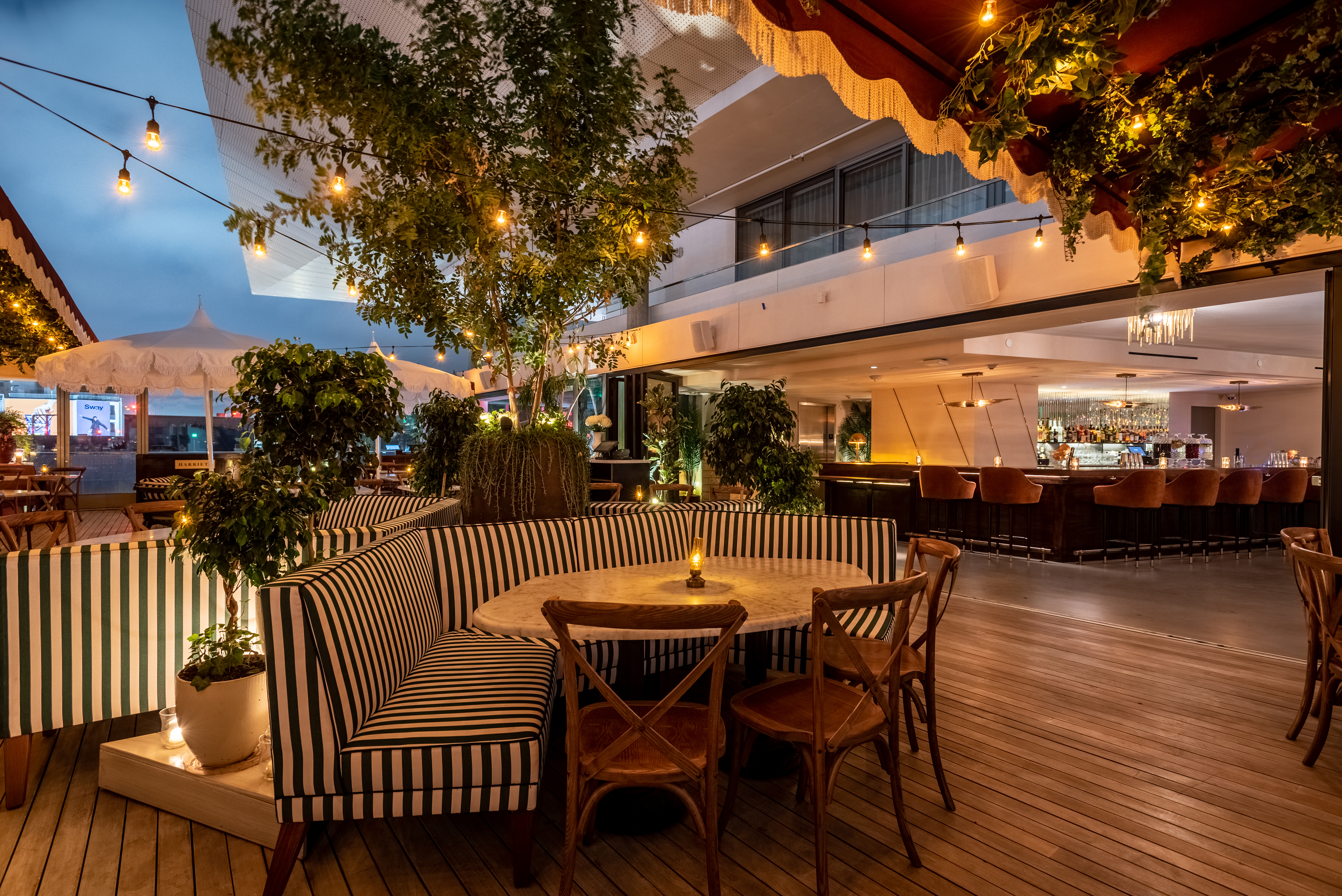 Outdoor dining area at dusk with striped benches