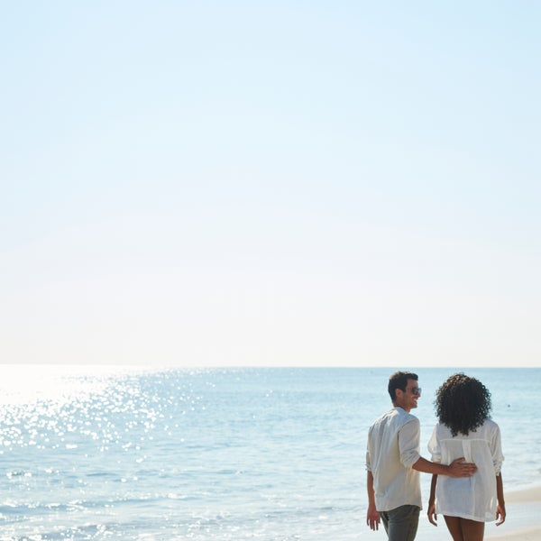 Two people walking on the beach