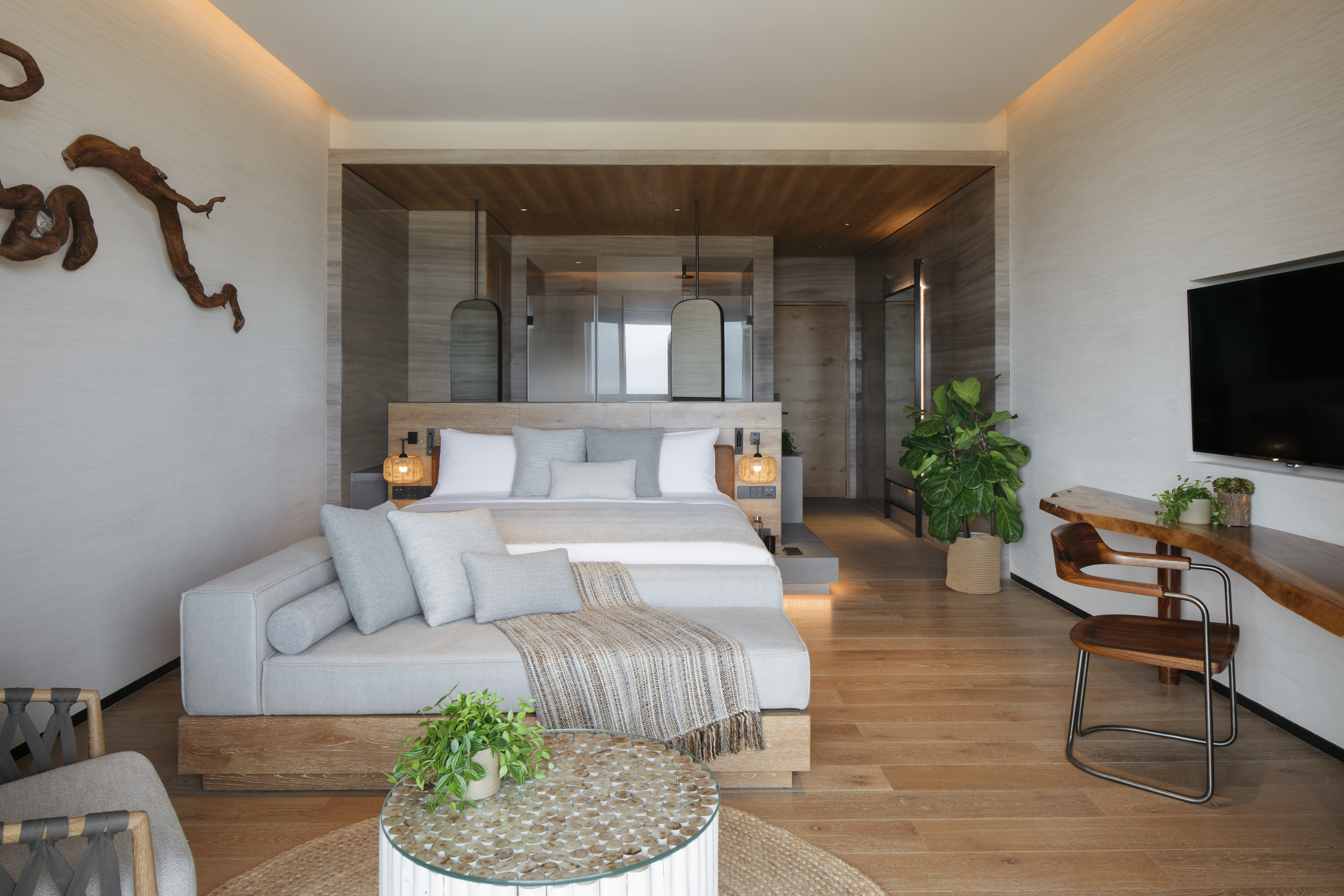 A couch and a bed in the Ocean Pool View room at 1 Hotel Haitang Bay