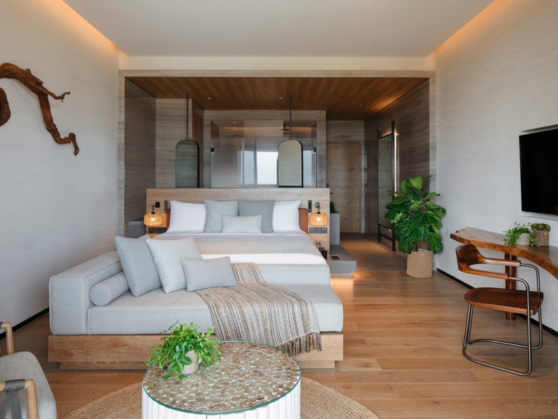 A couch and a bed in the Ocean Pool View room at 1 Hotel Haitang Bay