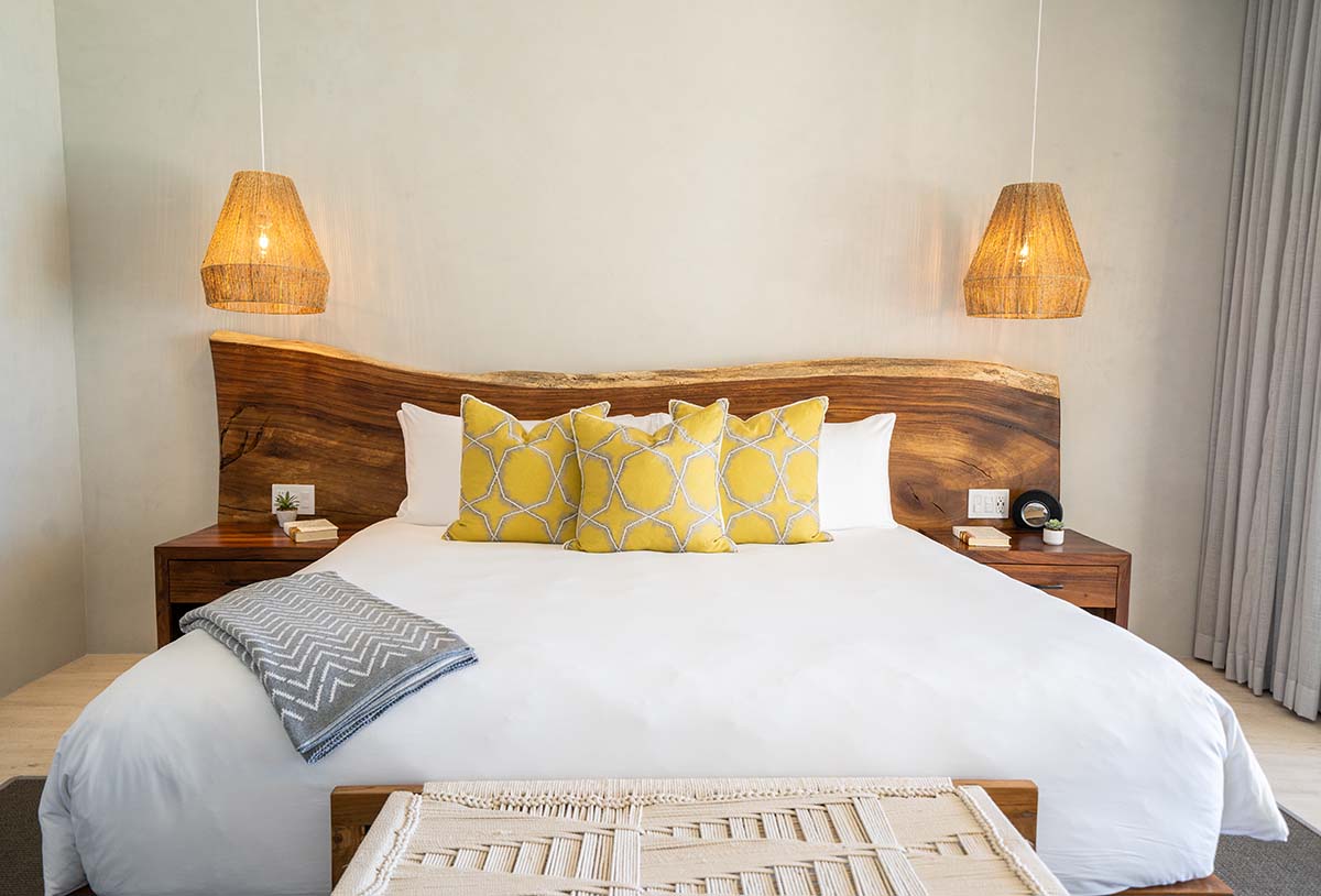 A made bed with yellow pillows