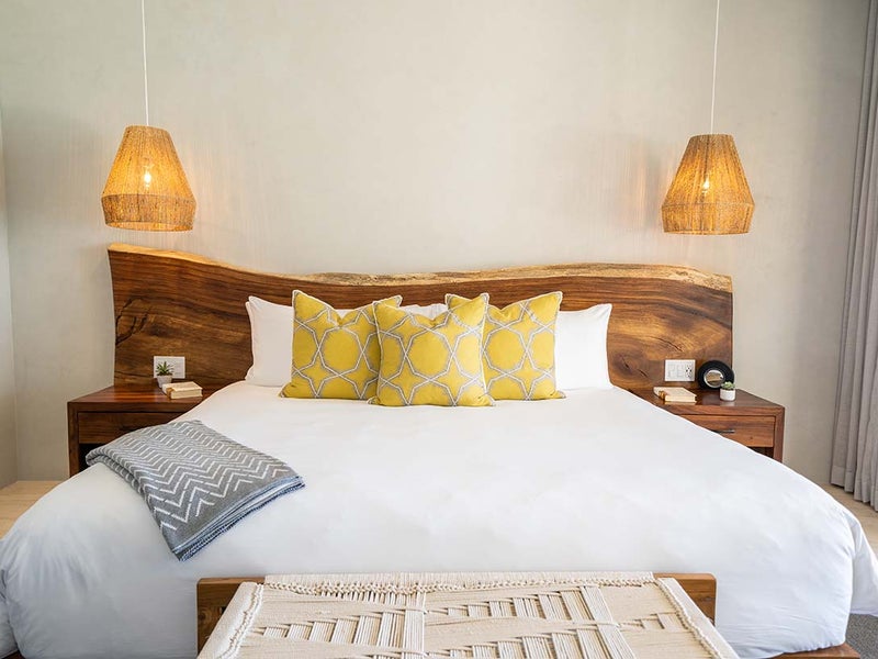 A made bed with yellow pillows