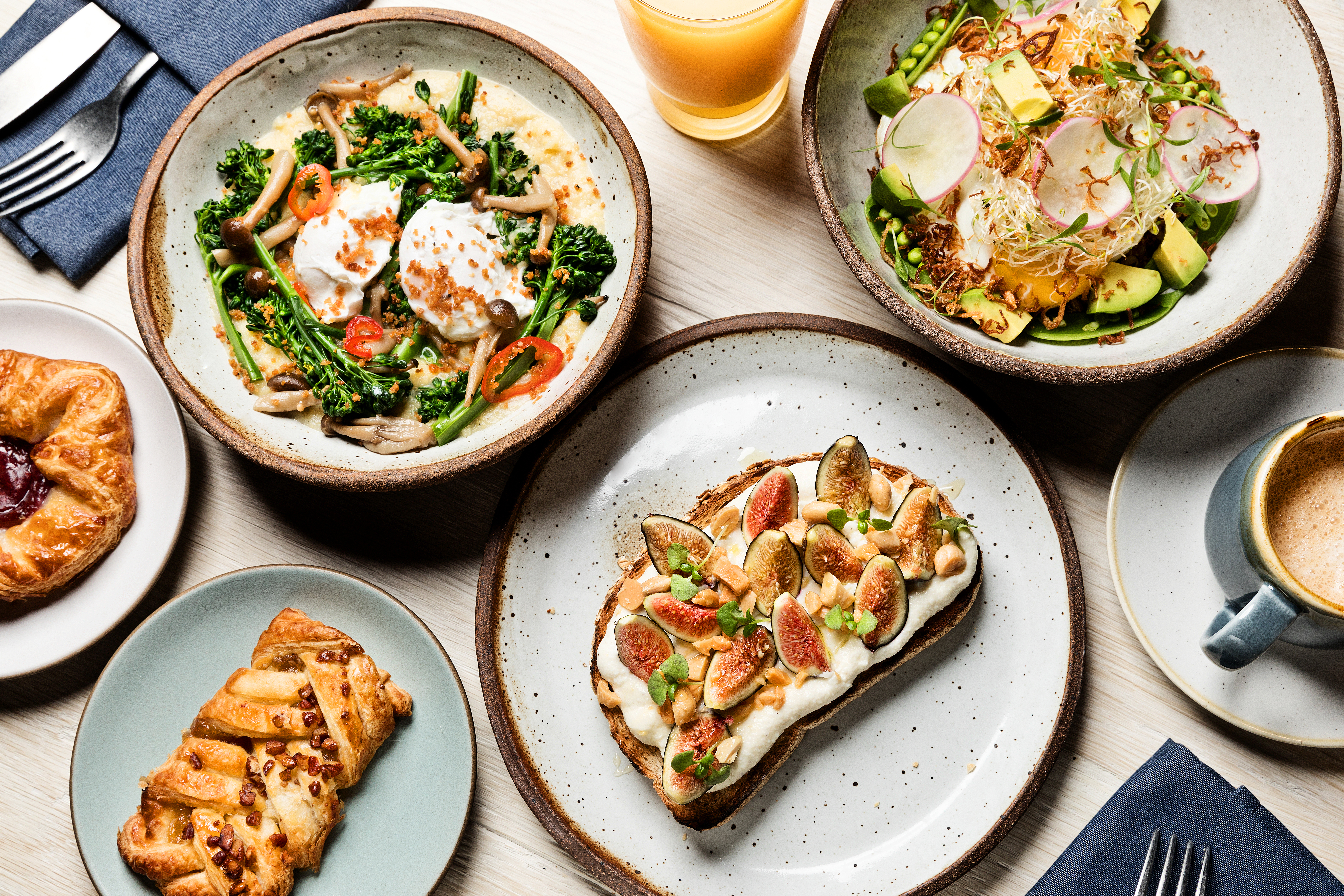 A table spread of varying dishes prepared by 1 Hotels kitchen for breakfast