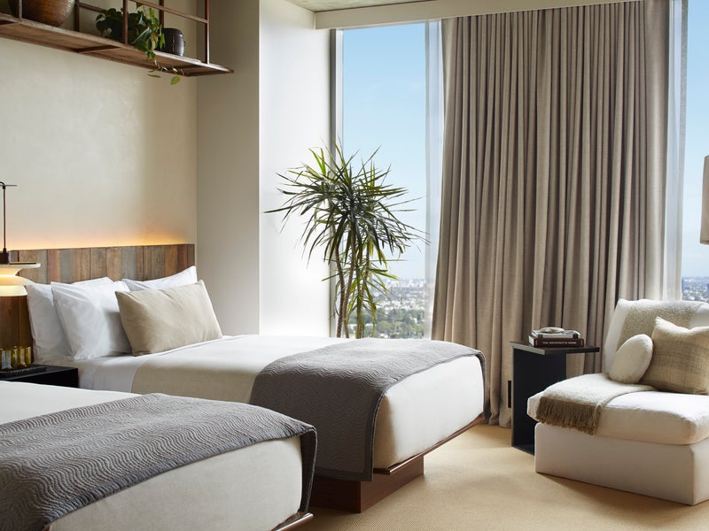 Two beds side by side with views of the city 