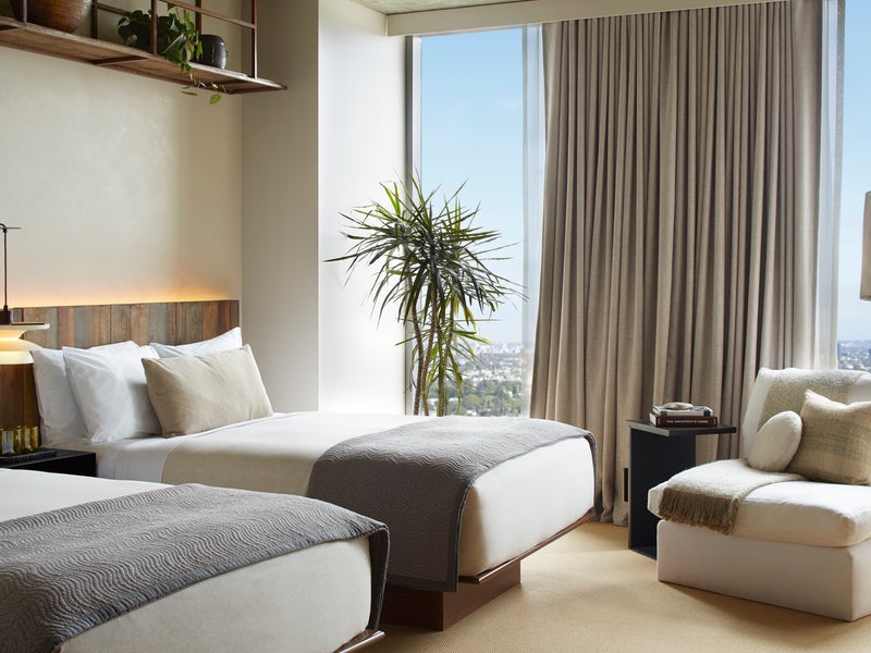 Two beds side by side with views of the city