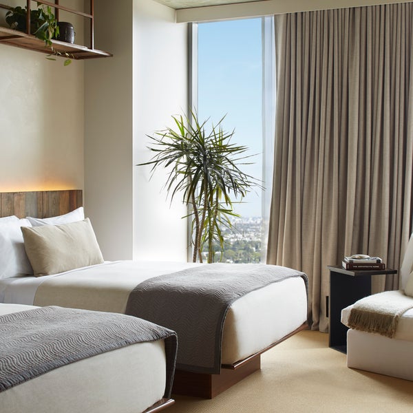 Two beds side by side with views of the city 