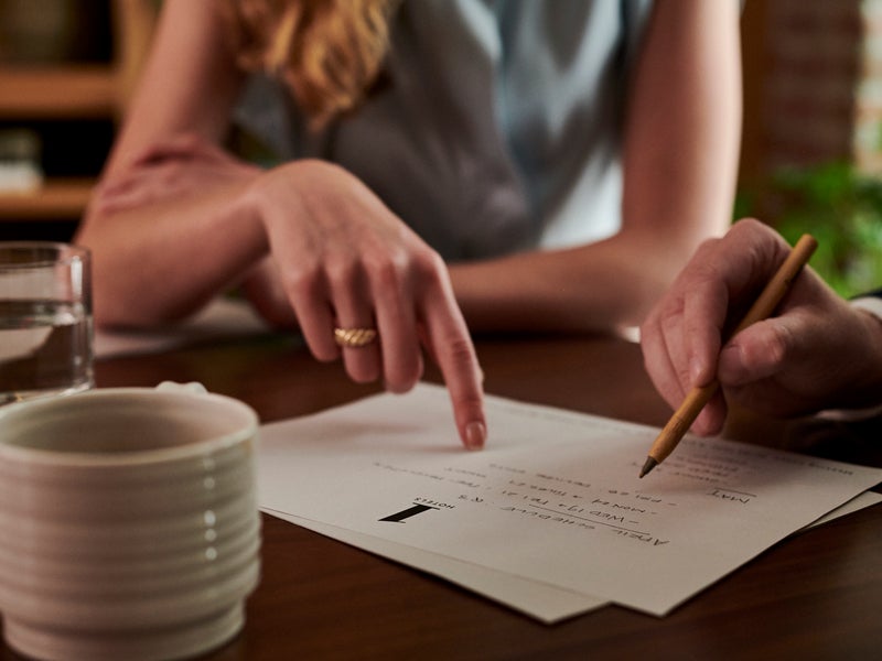 People pointing at notes on paper