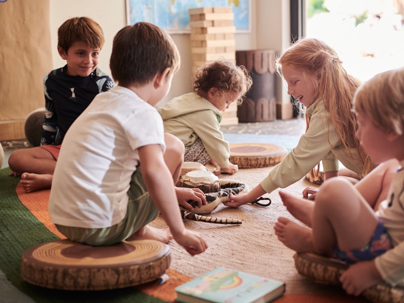 Children sitting on the floor playing quietly with toys inside a cozy room