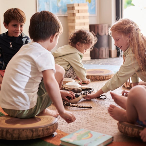 Children sitting on the floor playing quietly with toys inside a cozy room