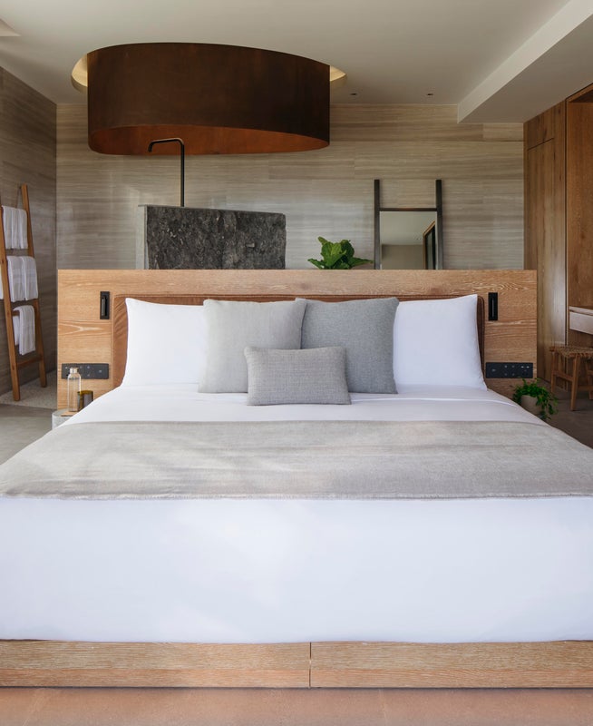 A made bed in the ocean pool view suite
