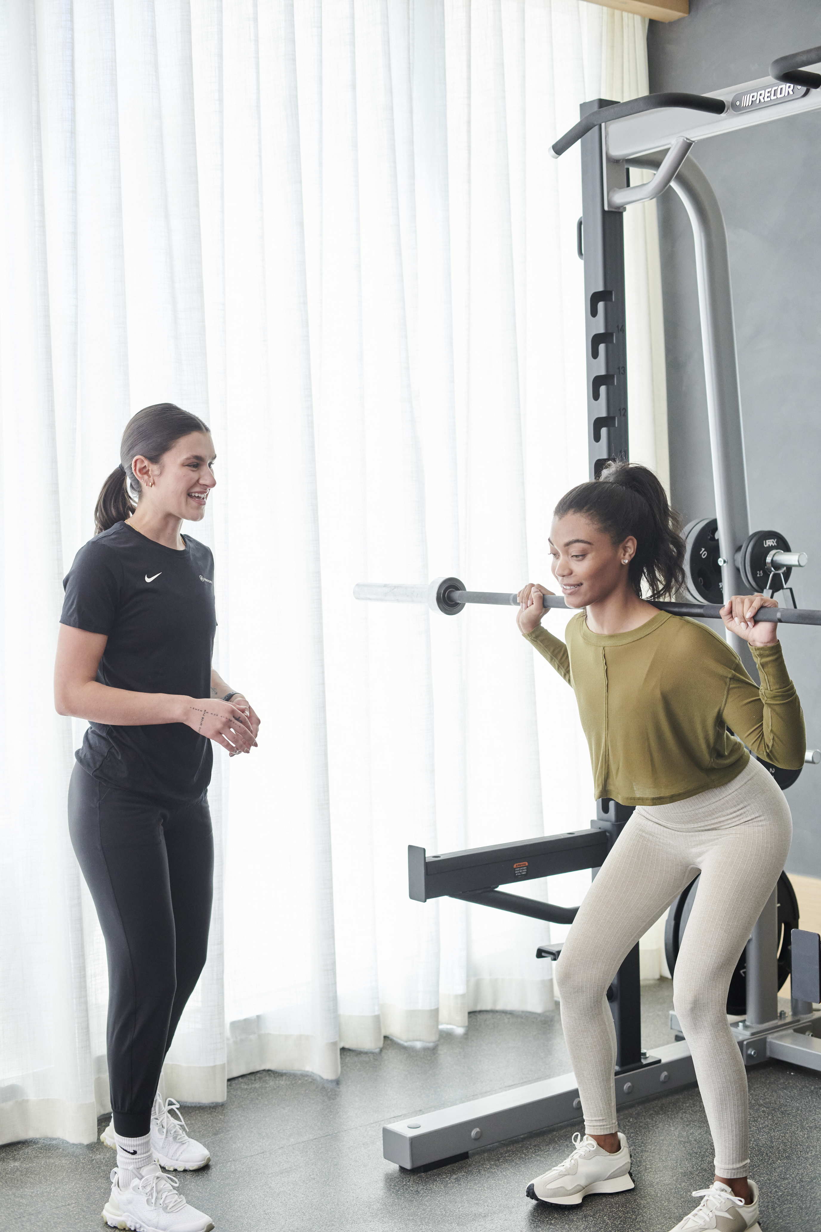 Personal trainer working with someone doing a squat