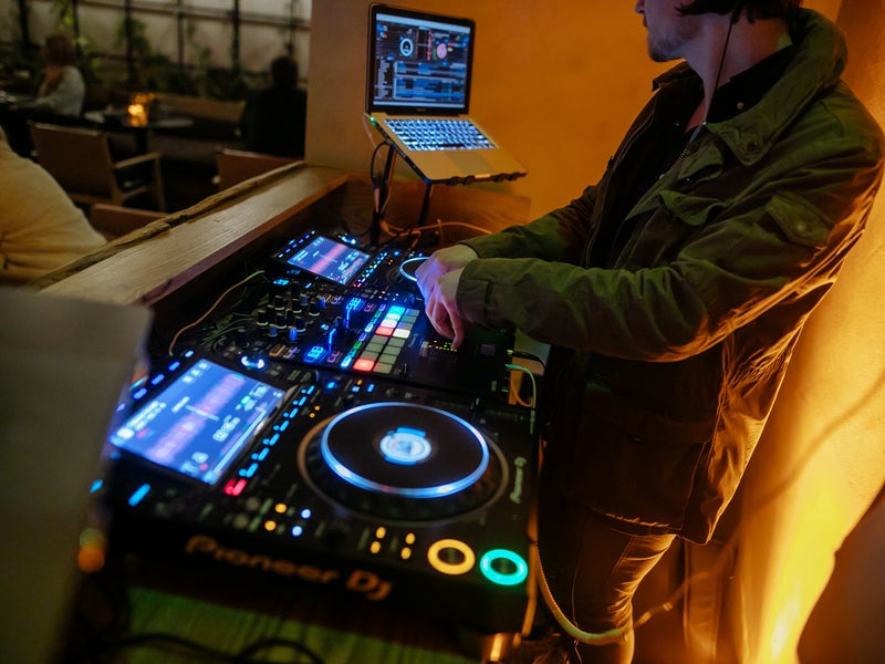 a person DJing, dj, sound board, event