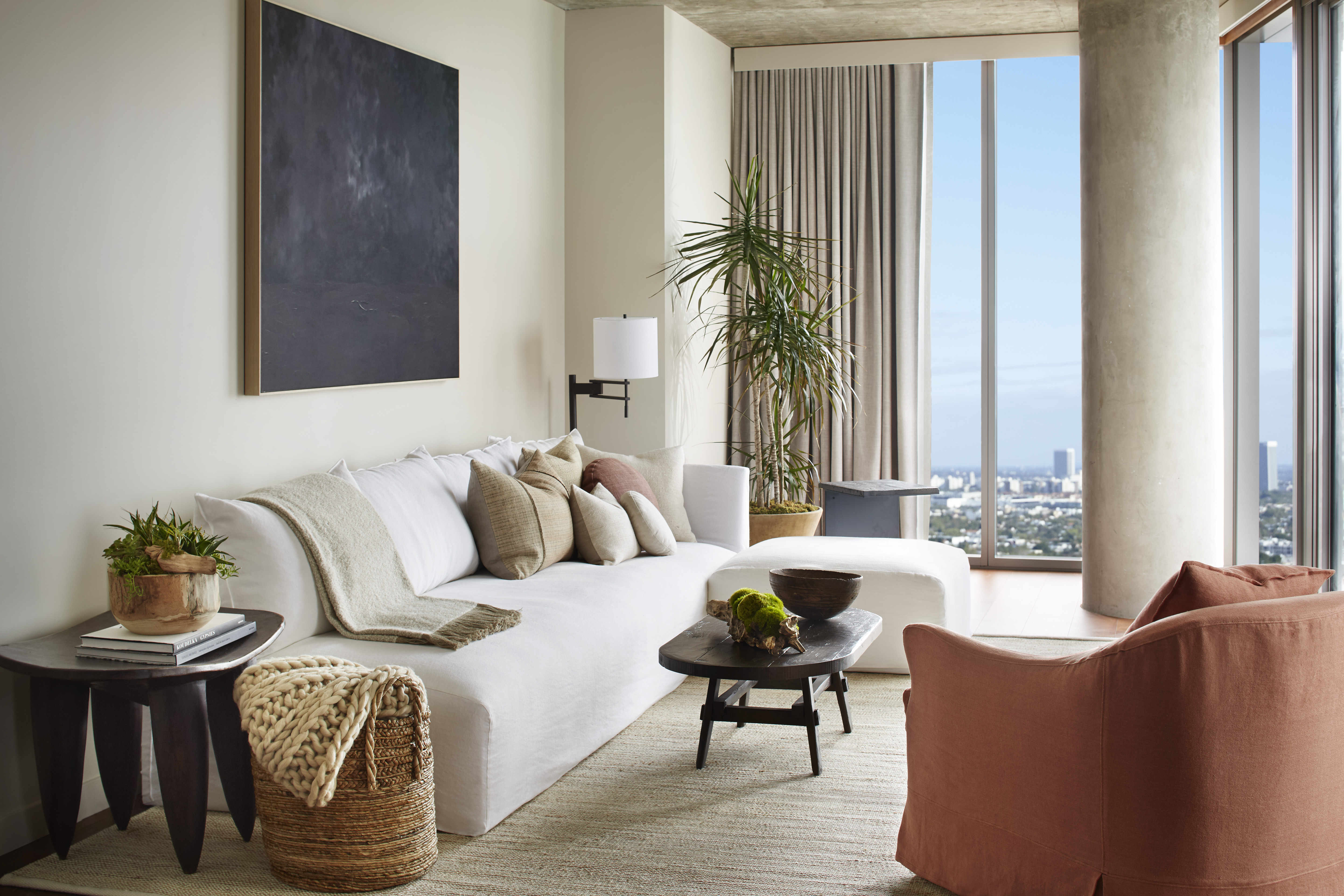 A white sofa sits against a wall with a solid black accent picture hung on the wall