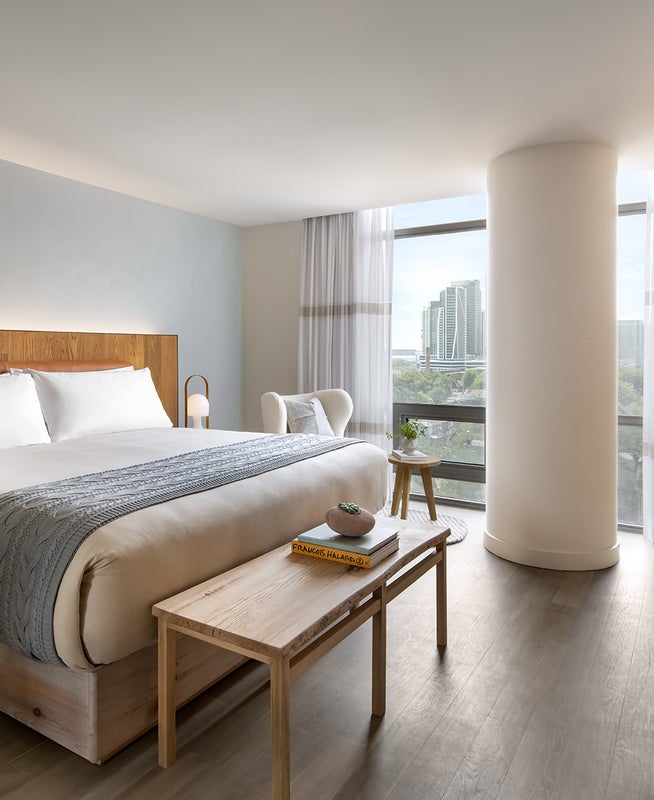 A king size bed with views of the city