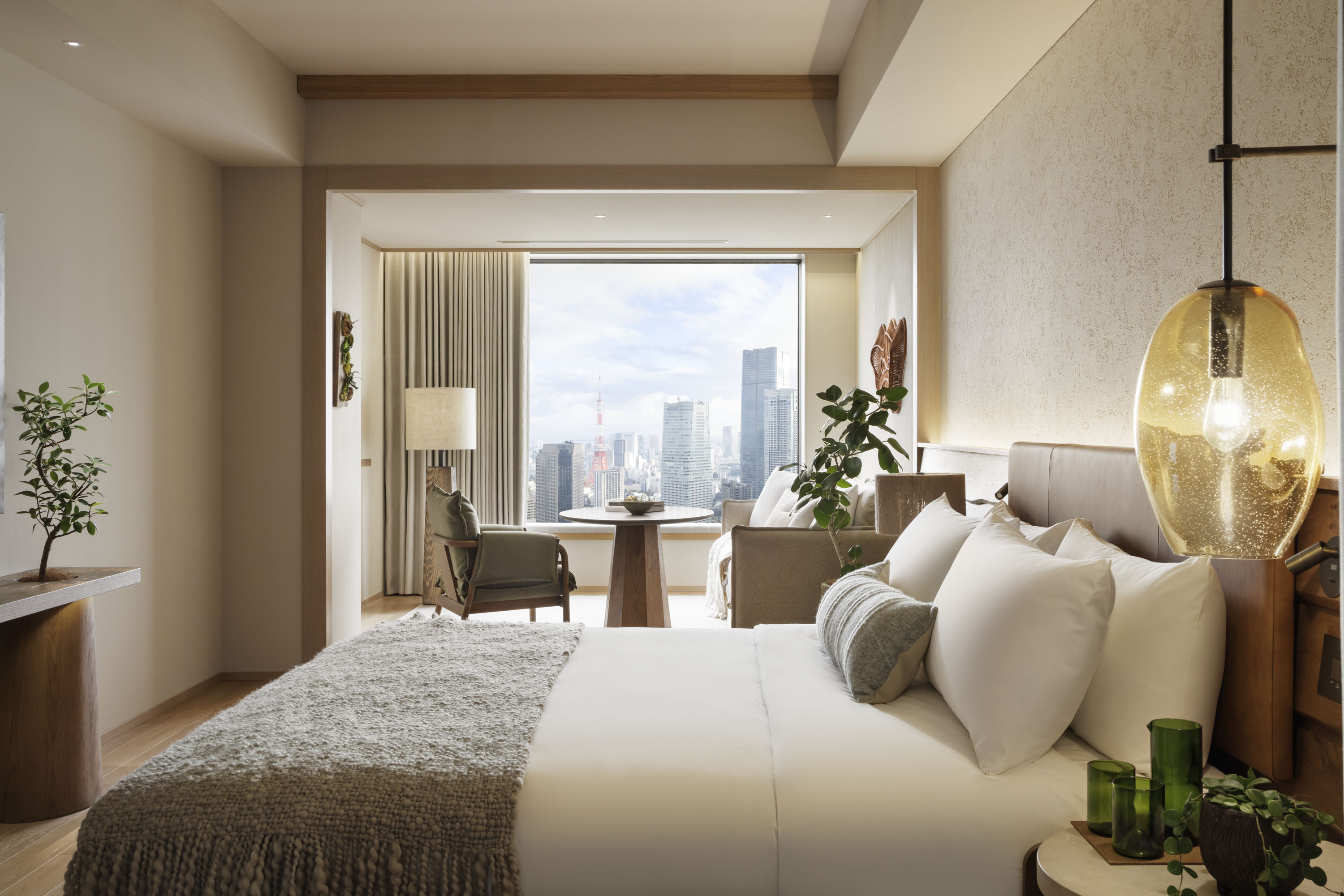 Modern bedroom with large windows, a tea table, chairs & couch